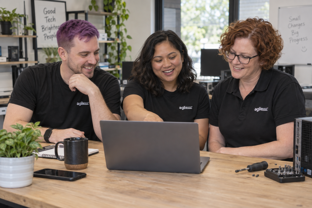 Illustrative Agile MSP-branded IT team collaborating at a laptop.